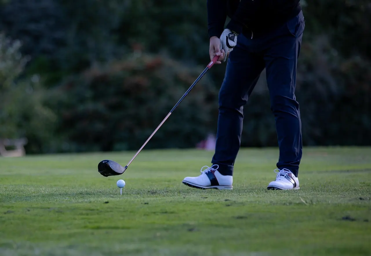 Golfspiller ved tee klar til drive